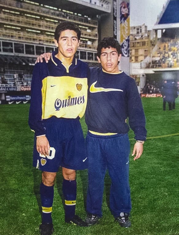 Juan Román RIQUELME - Carlos Alberto TEVEZ -  Club Atlético Boca Juniors -  - Soccer - Dos leyendas del equipo xeneize (Juan Román Riquelme posa en una foto al lado de un hincha más. Un joven delantero de las inferiores de Boca que funge como recoge pelotas en La Bombonera. ) Photo by:  | Siuxy Sports 1998-06-01